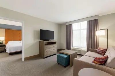 a hotel room with a couch and a flat screen tv at Homewood Suites By Hilton Carlisle in Carlisle