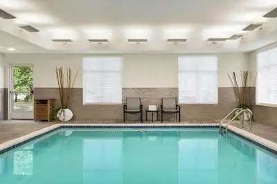 a pool in a hotel room with two chairs and a table at Homewood Suites By Hilton Carlisle in Carlisle