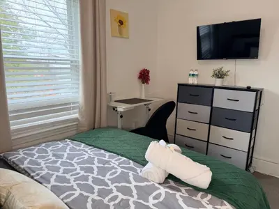 a bedroom with a bed and a desk and a television at Modern Room in Shared Apartment Near NYC in Englewood
