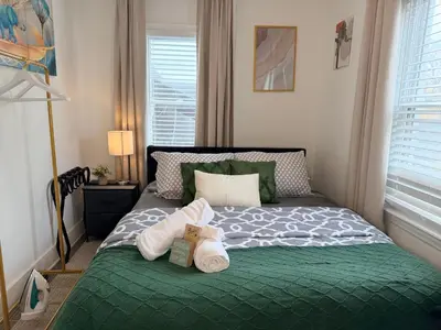 a bedroom with a green bed with towels on it at Modern Room in Shared Apartment Near NYC in Englewood