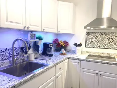 a kitchen with white cabinets and a sink at Modern Room in Shared Apartment Near NYC in Englewood