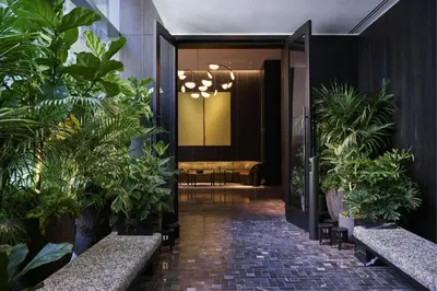 a hallway with potted plants in a lobby at The Ritz-Carlton New York, NoMad in New York