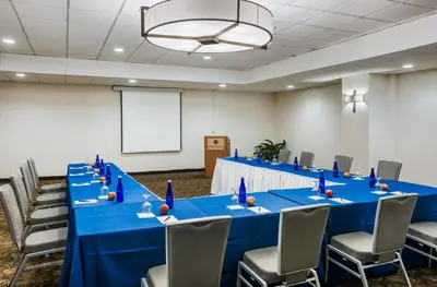 a conference room with a long blue table and chairs at The Kenilworth Hotel - Airport West in Kenilworth