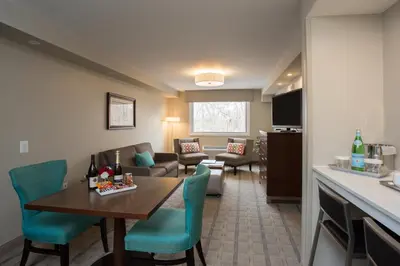a living room with a table and chairs in a room at The Kenilworth Hotel - Airport West in Kenilworth
