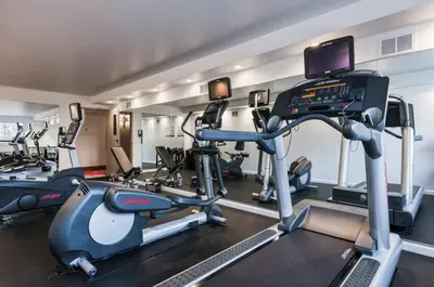 a gym with several tread machines and a treadmill at The Kenilworth Hotel - Airport West in Kenilworth