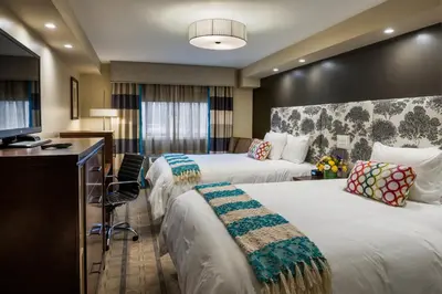 a hotel room with two beds and a desk at The Kenilworth Hotel - Airport West in Kenilworth
