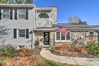 a stone house with an american flag on it at 20 Mi to Philly Inviting Home with Yard in Wayne! in Wayne