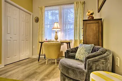 a living room with a chair and a table and a window at 13 Mi to Camelback Ski! Creekside Lincoln Lodge in Brodheadsville