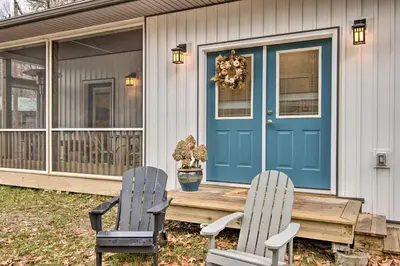 two chairs and a table on a house with a blue door at 13 Mi to Camelback Ski! Creekside Lincoln Lodge in Brodheadsville