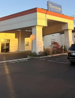 a car parked in a parking lot in front of a car dealership at Travelodge by Wyndham Bellmawr in Bellmawr