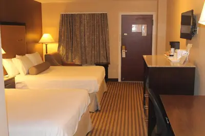 a hotel room with two beds and a desk at Travelodge by Wyndham Bellmawr in Bellmawr