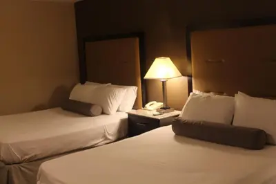 a hotel room with two beds and a telephone at Travelodge by Wyndham Bellmawr in Bellmawr