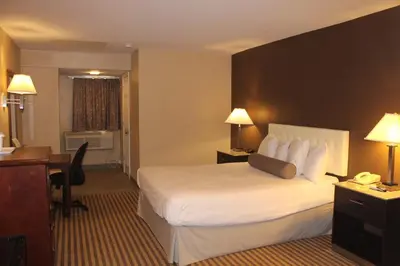 a hotel room with a bed and a desk at Travelodge by Wyndham Bellmawr in Bellmawr