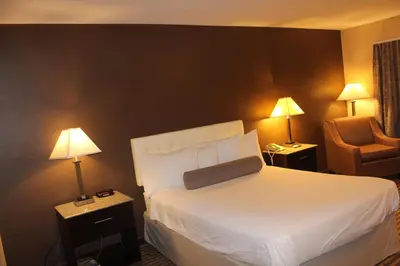 a hotel room with a bed and a chair at Travelodge by Wyndham Bellmawr in Bellmawr