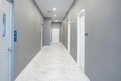 a hallway with gray walls and a tile floor at Peachtree Suites - Jersey City in Jersey City