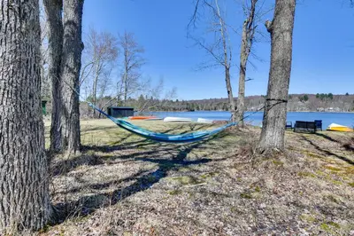 a blue hammock sitting between two trees next to a lake at Kayaks and Canoes Lake-View Retreat in Ellenville! in Ellenville