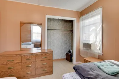 a bedroom with a dresser and a large mirror at Shared Lake Access and Fire Pit Catskills Getaway! in Ellenville