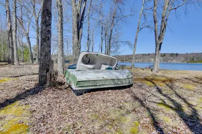 an old truck parked in a field next to a tree at Shared Lake Access and Fire Pit Catskills Getaway! in Ellenville