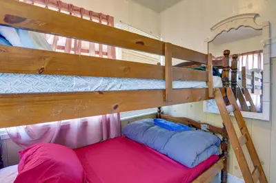 a bedroom with two bunk beds and a ladder at Shared Lake Access and Fire Pit Catskills Getaway! in Ellenville