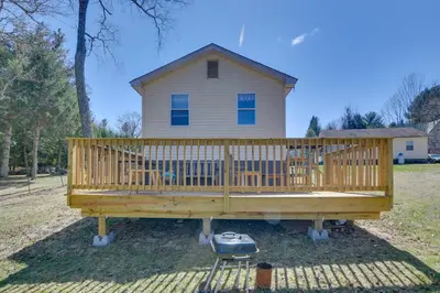 a large wooden deck with a house in the background at Shared Fire Pit and Kayaks Catskills Lake Retreat! in Ellenville