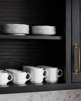 a row of white cups and plates on a shelf at The Hotel Chelsea in New York