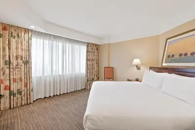 a hotel room with a bed and a large window at Harmony Suites Secaucus Meadowlands in Secaucus