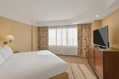 a hotel room with a bed and a flat screen tv at Harmony Suites Secaucus Meadowlands in Secaucus