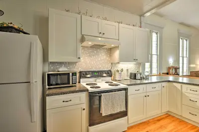 a kitchen with white cabinets and a stove top oven at Lisle Apt Fireplace and Stained Glass Windows! in Lisle