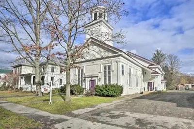 an old white church with a clock tower at Lisle Apt Fireplace and Stained Glass Windows! in Lisle