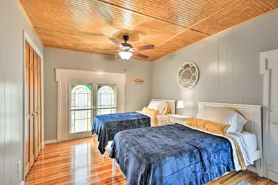 a bedroom with two beds and a ceiling fan at Lisle Apt Fireplace and Stained Glass Windows! in Lisle