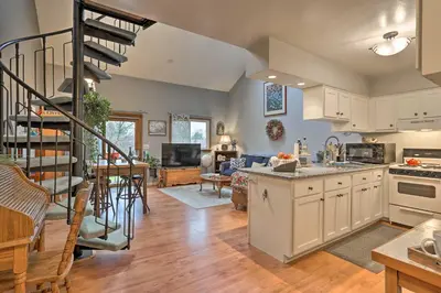 a kitchen and living room with a spiral staircase at Pet-Friendly Townhome with Community Hot Tub! in Vernon Township