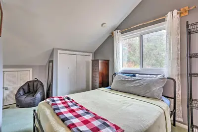 a bedroom with a bed and a window and a chair at Pet-Friendly Townhome with Community Hot Tub! in Vernon Township