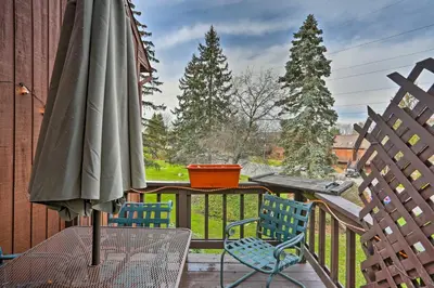a patio with a table and an umbrella on a balcony at Pet-Friendly Townhome with Community Hot Tub! in Vernon Township
