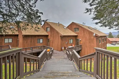 a wooden walkway leading up to two wooden buildings at Pet-Friendly Townhome with Community Hot Tub! in Vernon Township