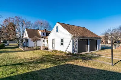a white house with a garage in a yard at 