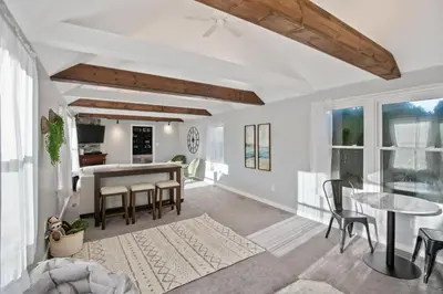 a living room with white walls and a ceiling with exposed beams at 