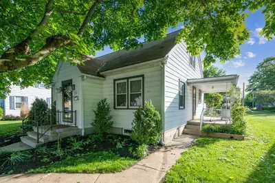 a small white house with a yard at 