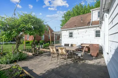 a backyard patio with a wooden table and chairs at 