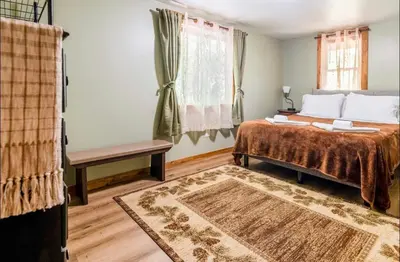 a bedroom with a bed and a window and a rug at The Nook Lodge - cabin with hot tub at Shawnee and Camelback Mtn in East Stroudsburg