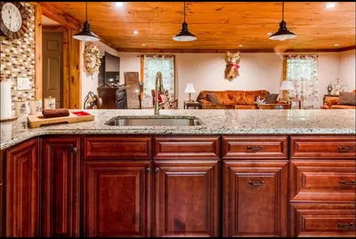 a kitchen with a sink and a living room at The Nook Lodge - cabin with hot tub at Shawnee and Camelback Mtn in East Stroudsburg