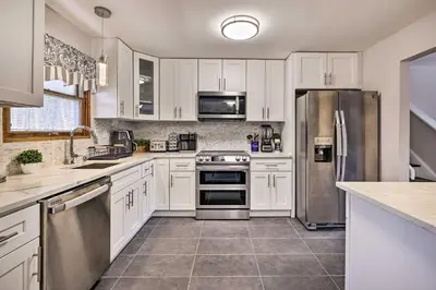 a kitchen with white cabinets and stainless steel appliances at Modern East Stroudsburg Home with Pool and Fire Pit in East Stroudsburg