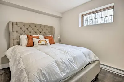 a bedroom with a large bed with orange pillows at Modern East Stroudsburg Home with Pool and Fire Pit in East Stroudsburg
