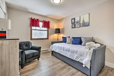 a bedroom with a bed and a chair at Modern East Stroudsburg Home with Pool and Fire Pit in East Stroudsburg