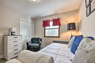 a bedroom with a bed and a chair at Modern East Stroudsburg Home with Pool and Fire Pit in East Stroudsburg