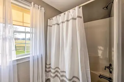 a shower curtain in a bathroom with a window at Peaceful Bird in Hand Home with Farmland Views! in Bird in Hand
