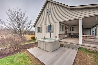 a house with a hot tub on a deck at Peaceful Bird in Hand Home with Farmland Views! in Bird in Hand