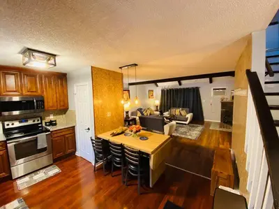 a kitchen and living room with a table and chairs at Aquatopia Waterpark-Pool-Tennis-Paintball- ZipLine 127 in Tannersville