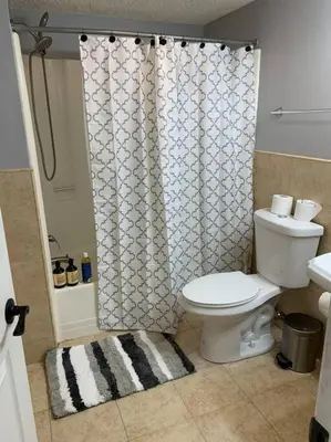 a bathroom with a toilet and a shower curtain at Aquatopia Waterpark-Pool-Tennis-Paintball- ZipLine 127 in Tannersville