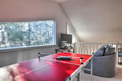 a living room with a red table and a couch at Hot Tub, Fire Pit and Game Room Tobyhanna Home! in Tobyhanna