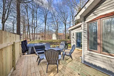 a patio with a table and chairs on a deck at Hot Tub, Fire Pit and Game Room Tobyhanna Home! in Tobyhanna